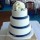 3 tier round wedding cake decorated with white Lisianthus and navy ribbon