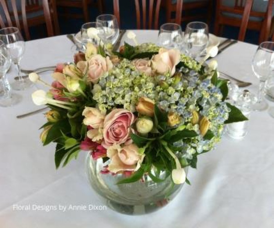 Summer fishbowl arrangement of soft blue hydrangea and pink roses