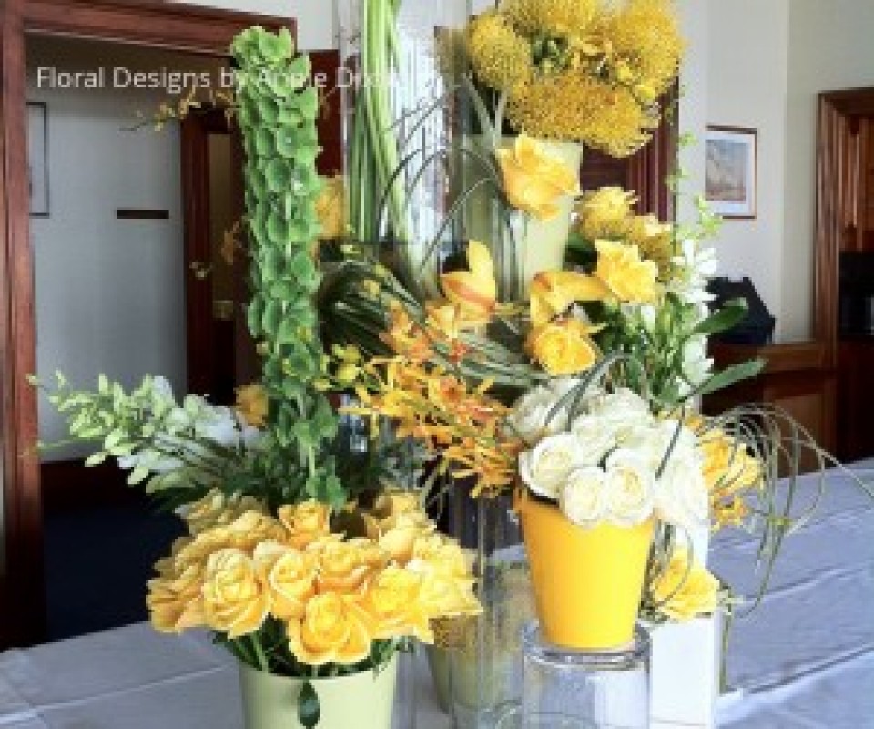 Contemporary buffet table arrangement of yellow and white flowers