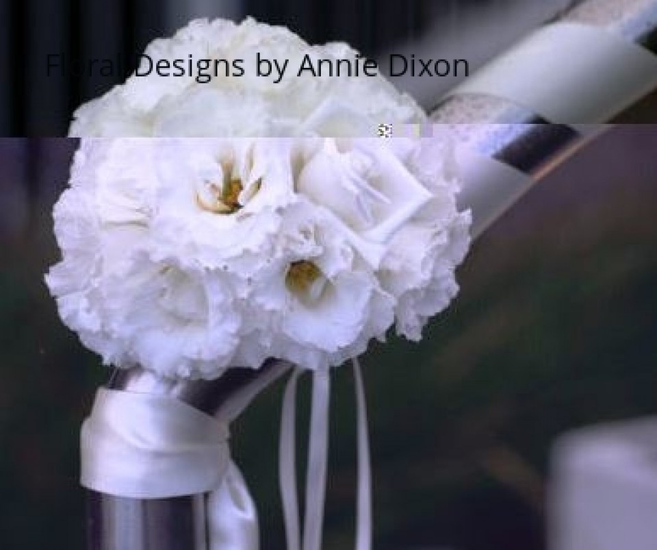 Posy of flowers on railing wrapped in satin ribbon