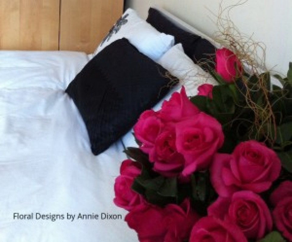 Bedside table arrangement of hot pink roses