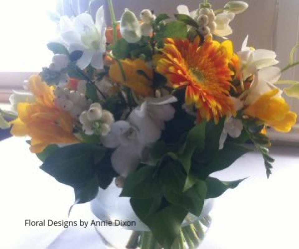 Fishbowl arrangement of yellow Gerberas, Snowberry and Singapore orchids in sunroom