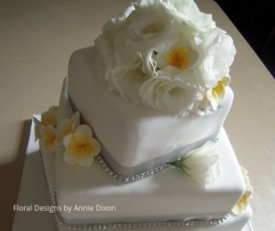 3 tier square wedding cake decorated with Lisianthus and Frangapanni decorations