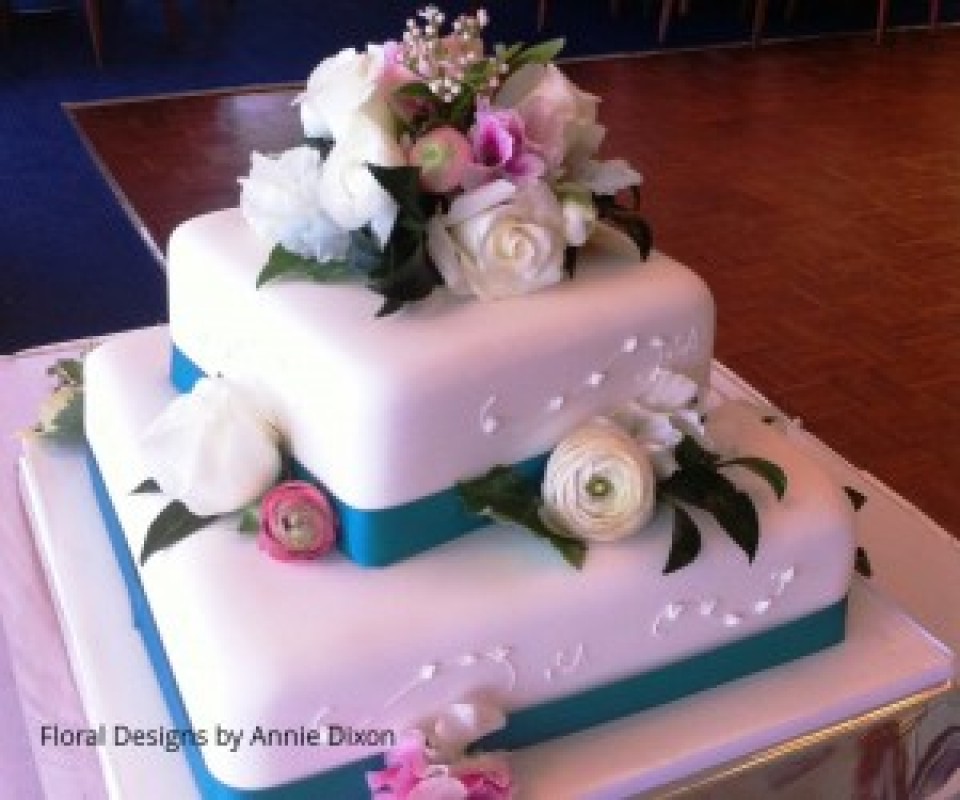2 tier square wedding cake decorated with pink and white Spring flowers