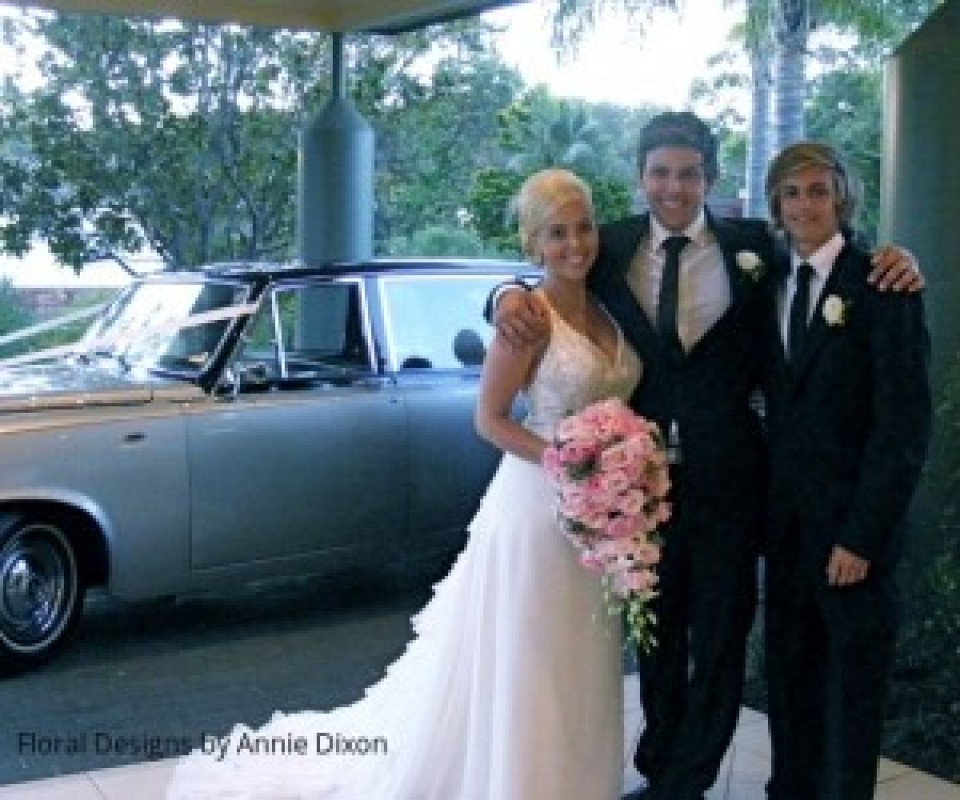 Bride holding a pastal pink teardrop bouquet, with the groom and his best man