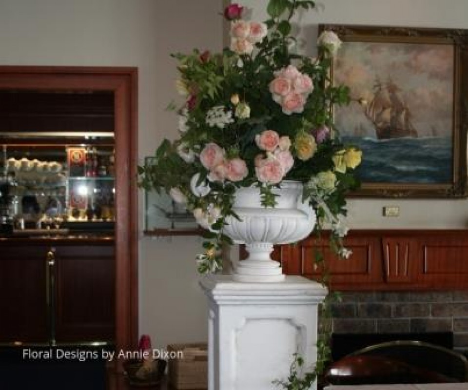 Classic urn arrangement of rambling roses on stone pedestal