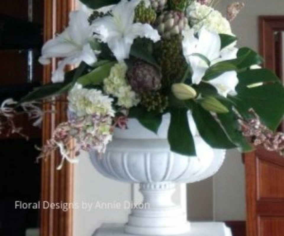 An arrangement of artichokes, Casablanca Lilies, Spider Orchids and Hydrangea in a classic urn