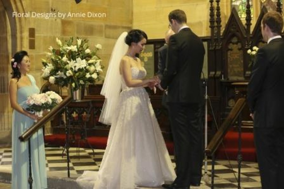 Church pedestal arrangement beside couple taking their vows
