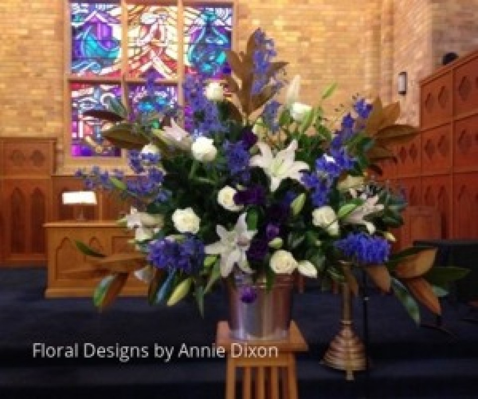 Large blue and white pedestal pedestal arrangement of Oriental lilies, Delphiniums and Roses in PLC chapel