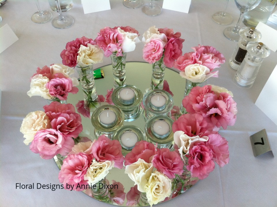 Circle of lisianthus and tealights on mirror