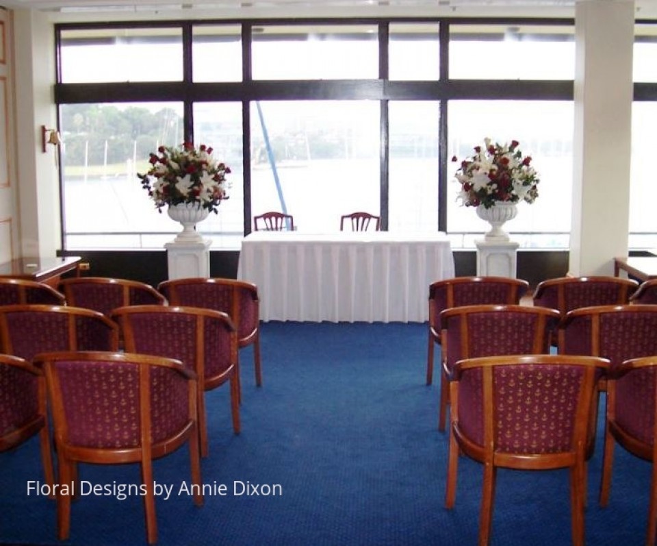 Indoor wedding ceremony set up including two classic urn pedestal arrangements
